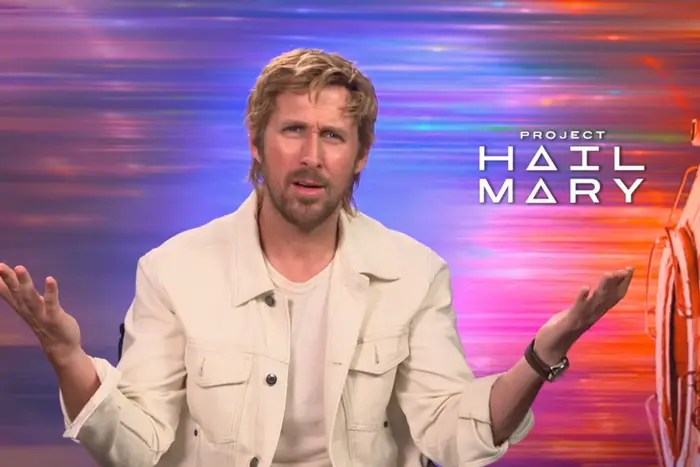 A man with light brown hair wearing a white jacket, looking confused or questioning while gesturing with his hands, with a colorful background and text that reads 'Project Hail Mary'.